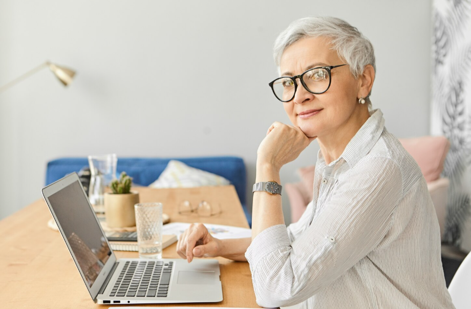 Confident senior woman working on a laptop past retirement age