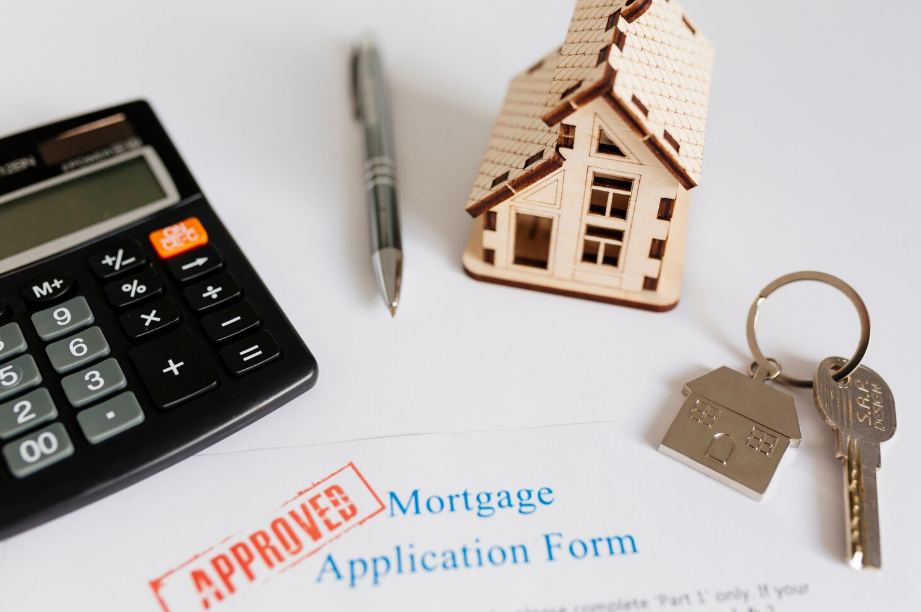 Mortgage application form with “Approved” stamp, house model and keys symbolizing reverse mortgage approval.