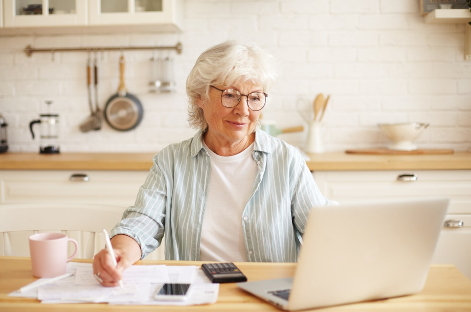 Older woman reviewing finances, planning how to maximize catch-up contributions for retirement savings.