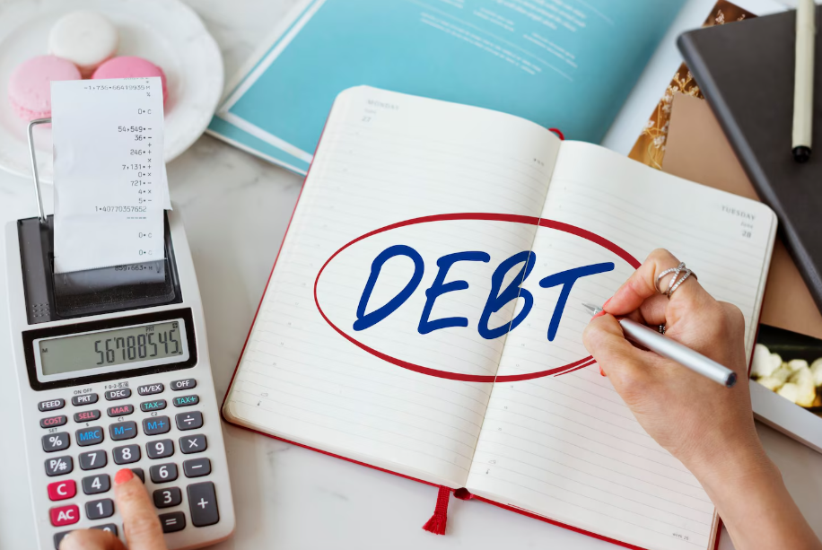 Close-up of budgeting process with calculator, receipts, and the word debt, symbolizing financial planning for debt-free retirement.