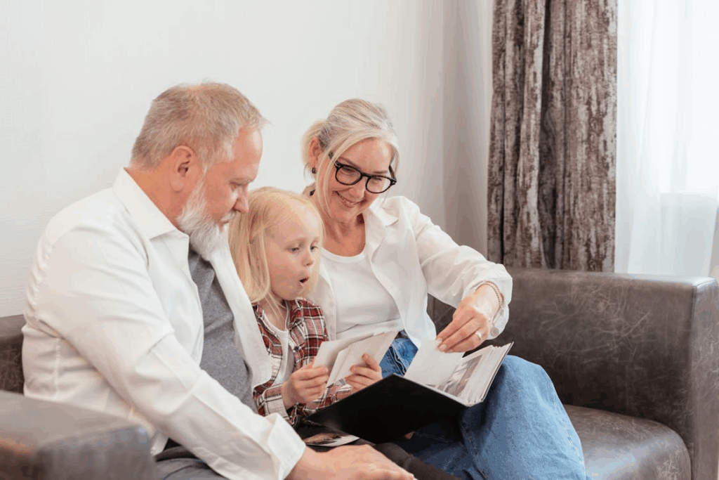 Grandparents sharing family photos with granddaughter, passing down memories and values as part of legacy planning after 50.