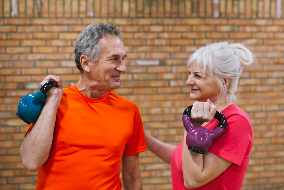 Active seniors lifting kettlebells, showing the health-wealth connection after 50 through fitness