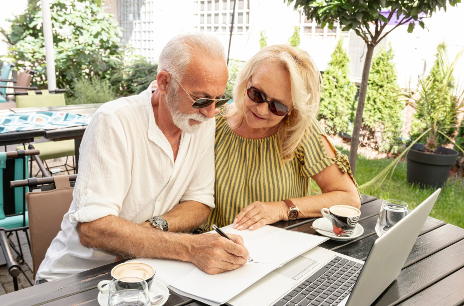 Retired couple working on their retirement budget together while enjoying coffee.