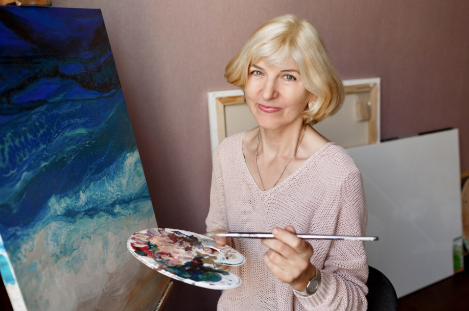 Woman painting in her art studio, showing how success after 50 can mean pursuing passions beyond career.