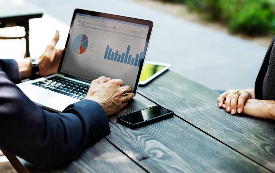 Financial advisor presenting investment charts on a laptop to discuss safe investments after 50.
