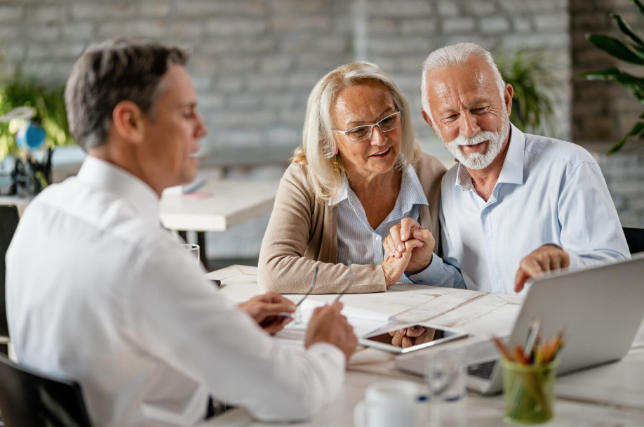 Senior couple meeting with financial advisor about life insurance for wealth-building after 50